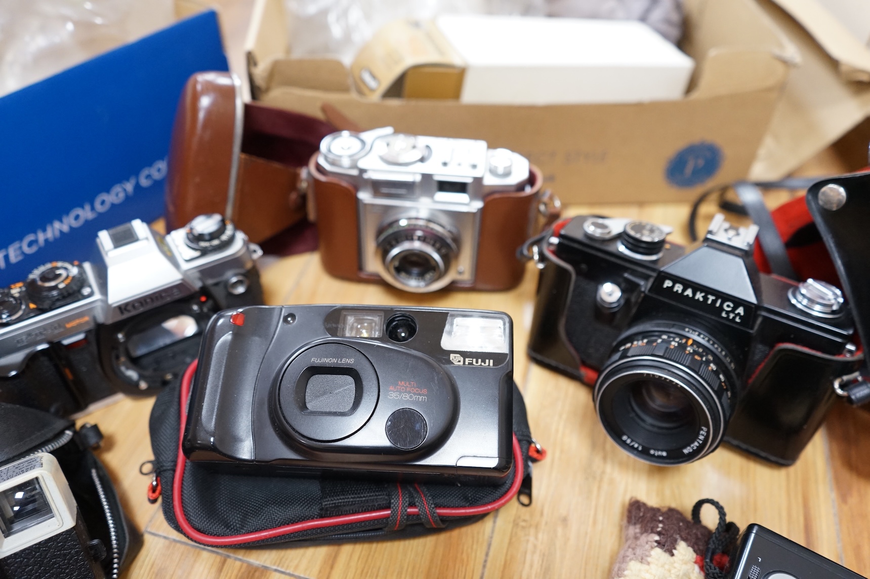 A collection of various cameras and camera equipment to include Konica